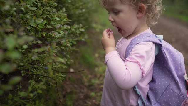 Girl eating blueberrys in forest