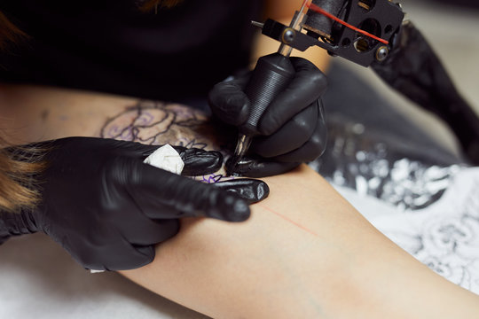 Close up of female tattoo artist working.