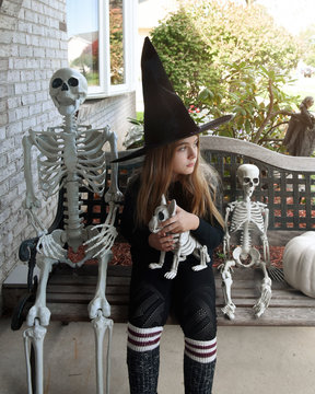 Child Witch Holding Scary Skeleton Dog
