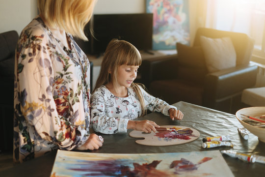 Artist painting at his home with daughter