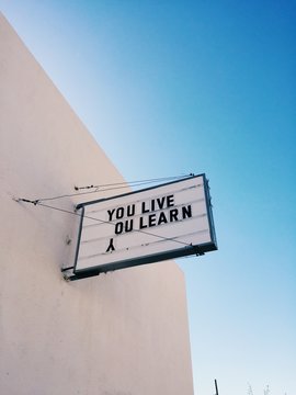 A sign that says ""You Live. You Learn""