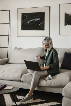 Woman with mug using laptop