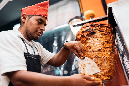 Chef cutting meat from meat roll