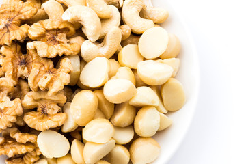 Some cashews, macadamias, and walnuts on a white background