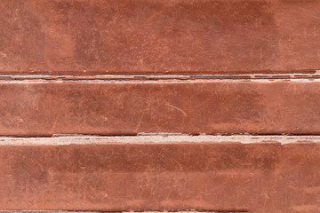 The textured background of old and scratched leather with horizontal marks produced by the crease.
