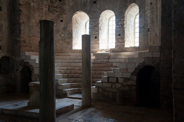 Column hall made of stone in some old castle or church with arches and okras