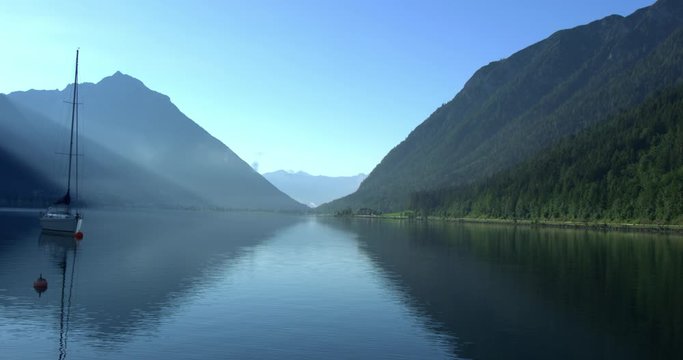 Steady shot, Scenic view Achensee lake in the morning, mountain range blue sky in the background.