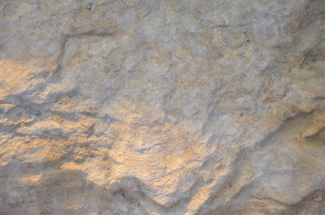 Details of sand stone texture, closeup shot of rock surface with vignette at cover and bright spot at centre, idea for background or backdrop.