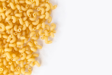 bright yellow pasta spirals on white surface with copy space