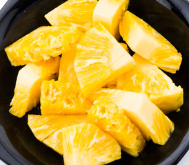 Sliced pineapple on a white plate, it is a sweet and juicy fruit.