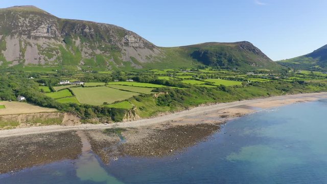 Bright Blue Sea Sea  With Lush Field And Rough Coast In Llyn Peninsula, Wales, UK - Wide Shot