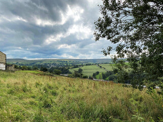 Fototapeta na wymiar View from the hills near Haworth, with trees, valleys and farmhouses, with heavy clouds near, Haworth, Keighley, UK