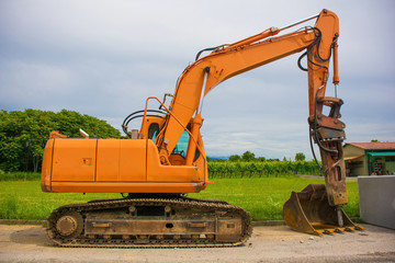 A crawler excavator with a rotating house platform and continuous caterpillar track on a sewer replacement work site in north west Italy
