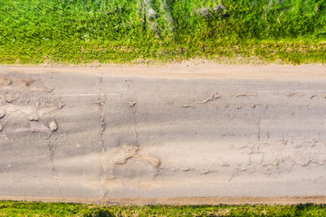 bad asphalt road with large holes top view, federal highway of the Vologda and Kostroma regions in...