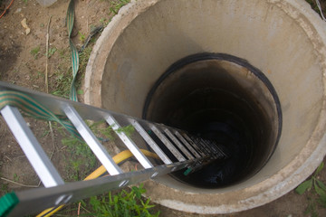 The staircase is lowered into a deep well made of concrete rings.