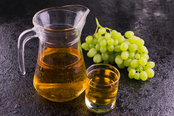 Glass with grape juice and a bunch of grapes on a black background.Copy space.