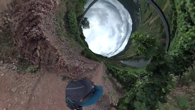 Mann wandert auf dem steilen Klettersteig durch den Weinberg bei Bremm.
Bearbeitetes 360-Grad Video, Tiny planet effekt, Little planet effekt
