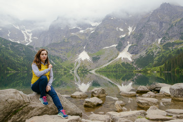 Naklejka premium woman relaxing on the lake and mountains sunny landscape