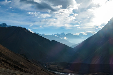 A new day beginning in Himalayas. Snow capped Himalayan peaks along Annapurna Circuit in Nepal. Barren and sharp slopes. Mountains are partially shrouded with clouds. Exploration and discovering.