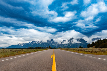 Scenic view of a road with the Grand Teton mountains on the background, in the State of Wyoming, USA