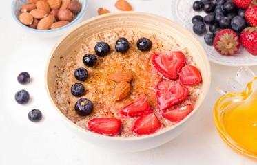 Healthy summer breakfast. Oatmeal porridge with fresh berries on a white plate