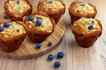 blueberry muffins with scattered berries on the wooden table