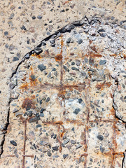 Reinforced concrete surface is covered with cracks, scratches, inclusions of granite and rusty metal bars. You can use as the background for any of your project.