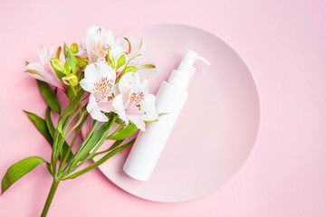 Cosmetic bottle with dispenser with bouquet blossom on pink circle frame background. Magazine page style. Cosmetics poster or banner design. Fresh modern wallpaper. Advertising banner