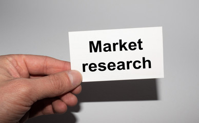 Message on the card MARKET RESEARCH, in hands of businessman.