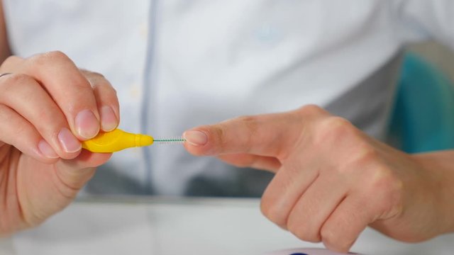 Oral hygiene for dental braces. Orthodontic Treatment concept. Female hands holding interdental brush for bracket system. Full hd