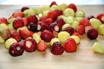 Strawberries red and white lies on a wooden Board. Ripe berries are close-up stacked in a pile. Horizontal background.