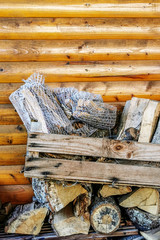Kasten mit Brennholz vor einer Holzwand