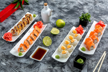 Assorted Japanese rolls on white plates.