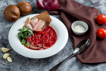 Borsch - Russian soup with beets, herbs and beef. Served with sour cream, black bread and bacon.