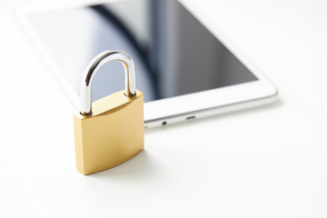 tablet with padlock near it over white background. digital data security concept. virus protection software concept