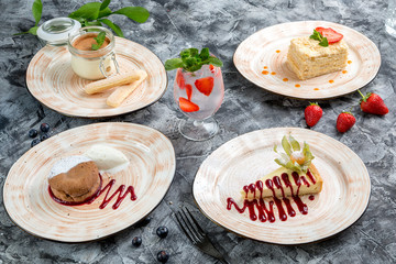 Four desserts. Honey cake, cheesecake, brownie and tiramisu. Berry lemonade.