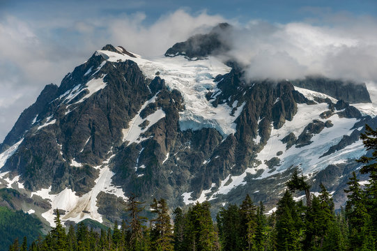 Mount Shuksan is a glaciated massif in the North Cascades National Park, Whatcom County, Washington. Mount Shuksan was first climbed by Asahel Curtis and W. Montelius Price on September 07, 1906. 