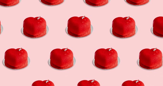 Pattern with many bright red desserts in the shape of a heart animated on a pink background, side view. cakes move in different directions, 4k
