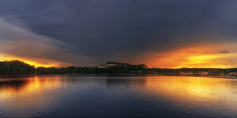 Fototapeta na wymiar Sunset over the lake. Beautiful panorama of the lake against the backdrop of the sunset sky.
