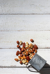 Various nuts on a white wooden background. Walnut, almonds, hazelnuts and cashews, pecans. Organic vegetarian food, healthy snacks.
