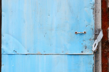Old metal blue door in an abandoned building