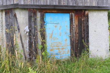 Old metal blue door in an abandoned building