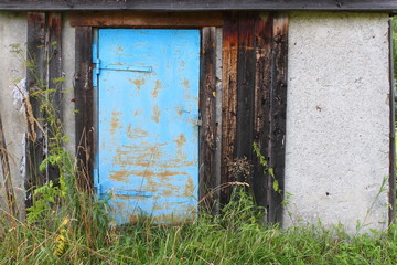 Old metal blue door in an abandoned building