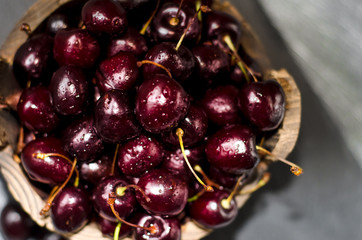 Ripe dark cherries in a wooden dish. Fruits and berries. The summer harvest.