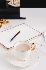 Cup of coffee in a gold desktop office in a white background