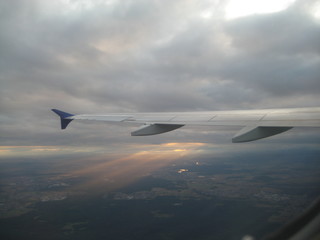 left wing of airplane flyinig in sunset