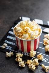 Sweet popcorn in cup and clappeboard.