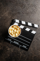 Sweet popcorn in cup and clappeboard.