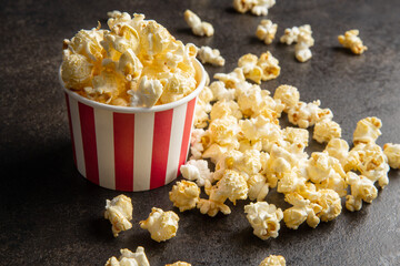 Sweet tasty popcorn in striped paper cup.