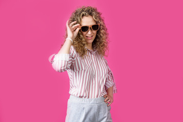 Portrait of a young, beautiful, healthy woman holding glasses and looking at the camera.